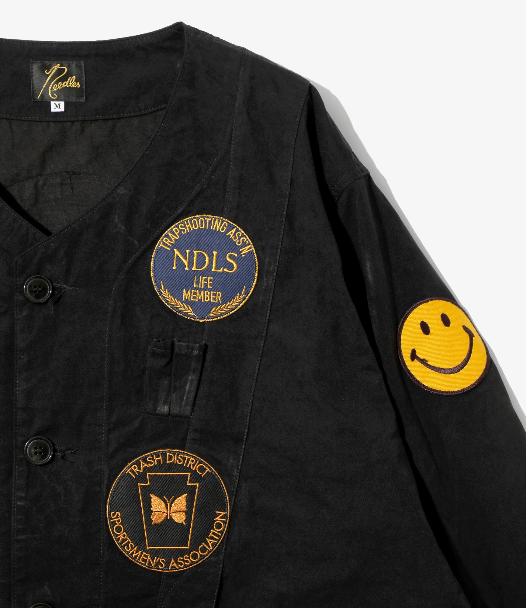 Black jacket with embroidered patches on a white background
