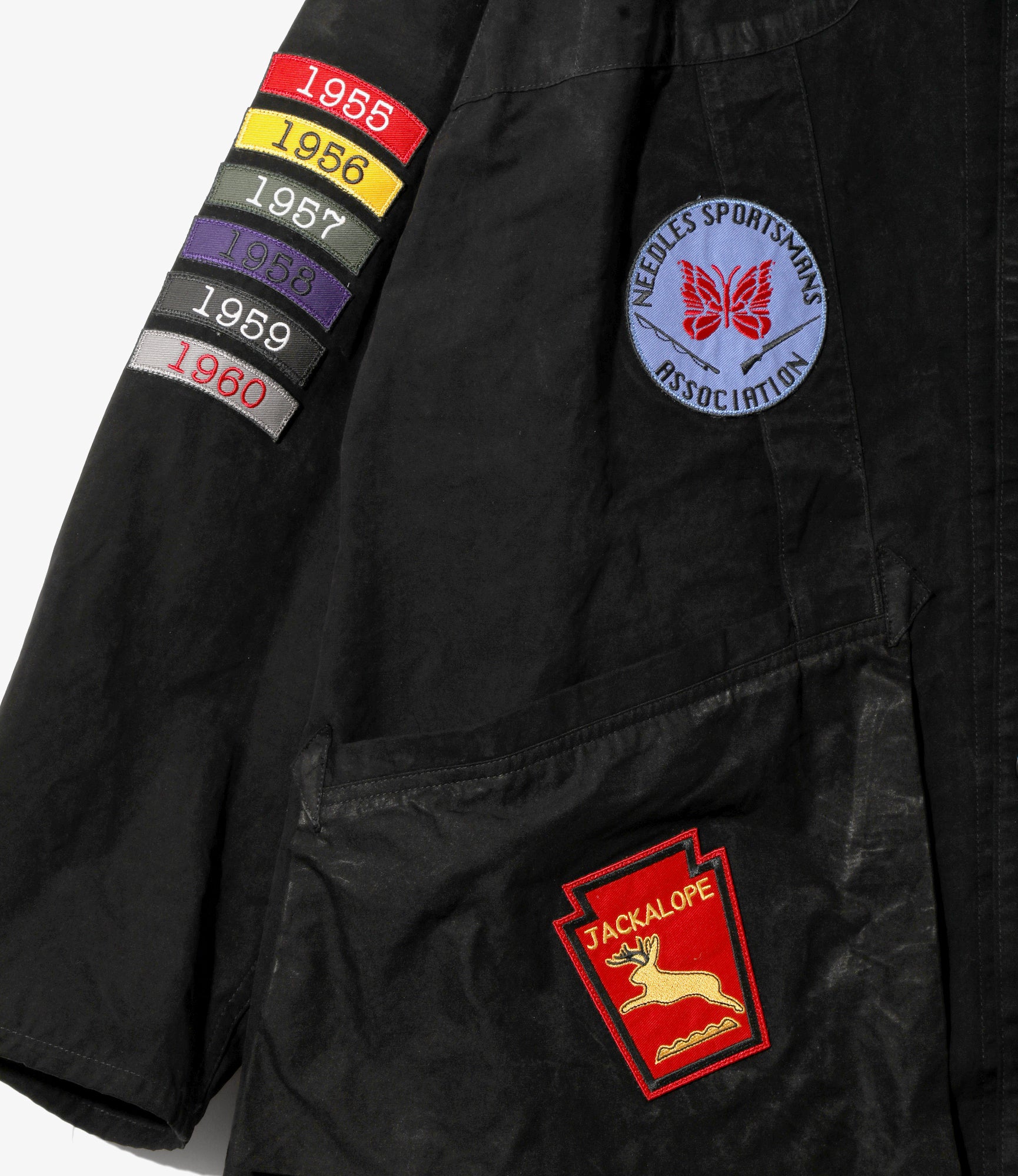 Black jacket with patches including a colorful year display and a red and blue logo.